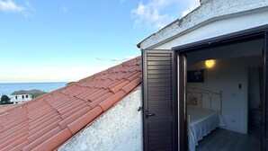 Une chambre avec un lit, une porte et une vue sur la mer.