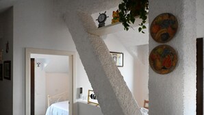 Une chambre à coucher avec un lit, un mur blanc et une porte donnant sur une autre pièce.
