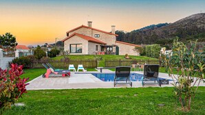 A house with a swimming pool, a fenced backyard, and a view of a hill.