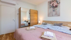 A bedroom with a large bed, a wardrobe, a mirror, and a painting on the wall. - Amazing home in Matulji (Matulji)
