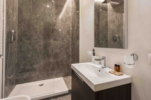 Chuveiro, secador de cabelo, toalhas de banho, shampoo