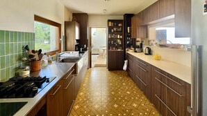 Una cocina moderna con armarios de madera, salpicadero de azulejos y suelo estampado.