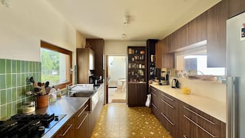 A modern kitchen with wooden cabinets, a tiled backsplash, and a patterned floor.