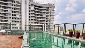 A rooftop pool with a view of a modern building. - Studio Brooklin 1min from the subway and close to the consulate (Brooklin São Paulo)