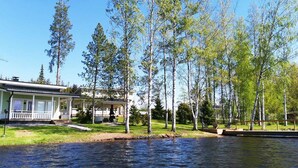 Une propriété au bord du lac, comprenant une maison, un quai et des arbres environnants.