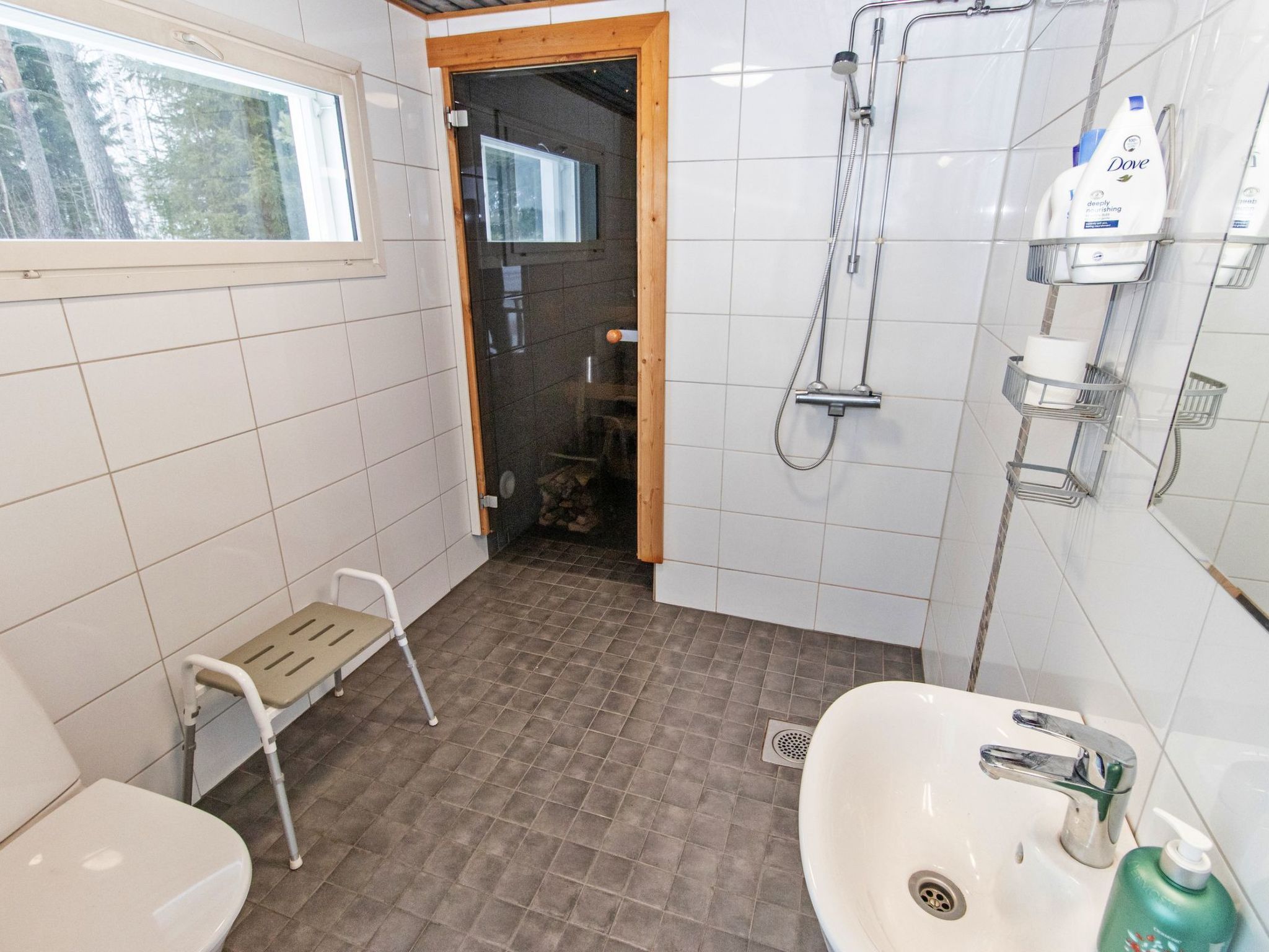 A bathroom with a shower, toilet, and sink.
