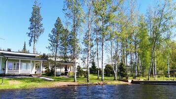Una proprietà sul lago con una casa, un molo e una zona verde.