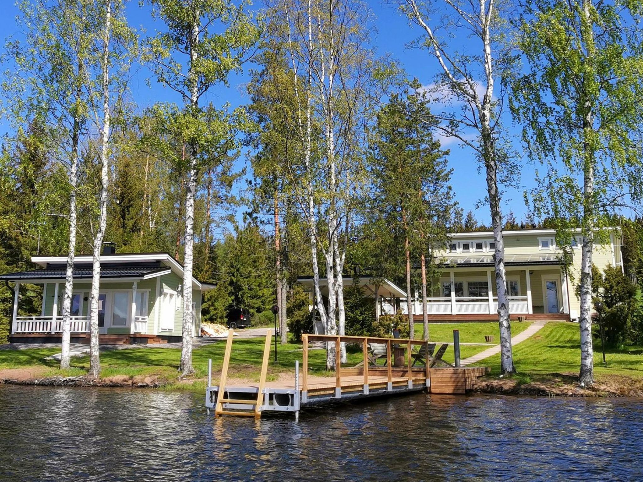 Järvenrantatontti, jossa on laituri, katettu terassi sekä kaksi päärakennusta, joissa on erilliset kuistit.