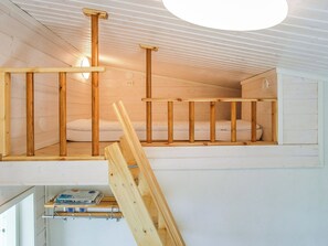 A wooden interior with a loft bed, a small desk, and a light fixture. - Villa onnela by Interhome (Hämeenkyrö)