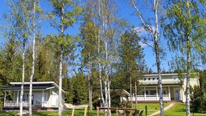 Une propriété au bord du lac, dotée d’un quai, de deux maisons et d’une zone herbeuse.