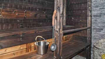 Un intérieur rustique en bois, avec un seau en métal posé sur une étagère.