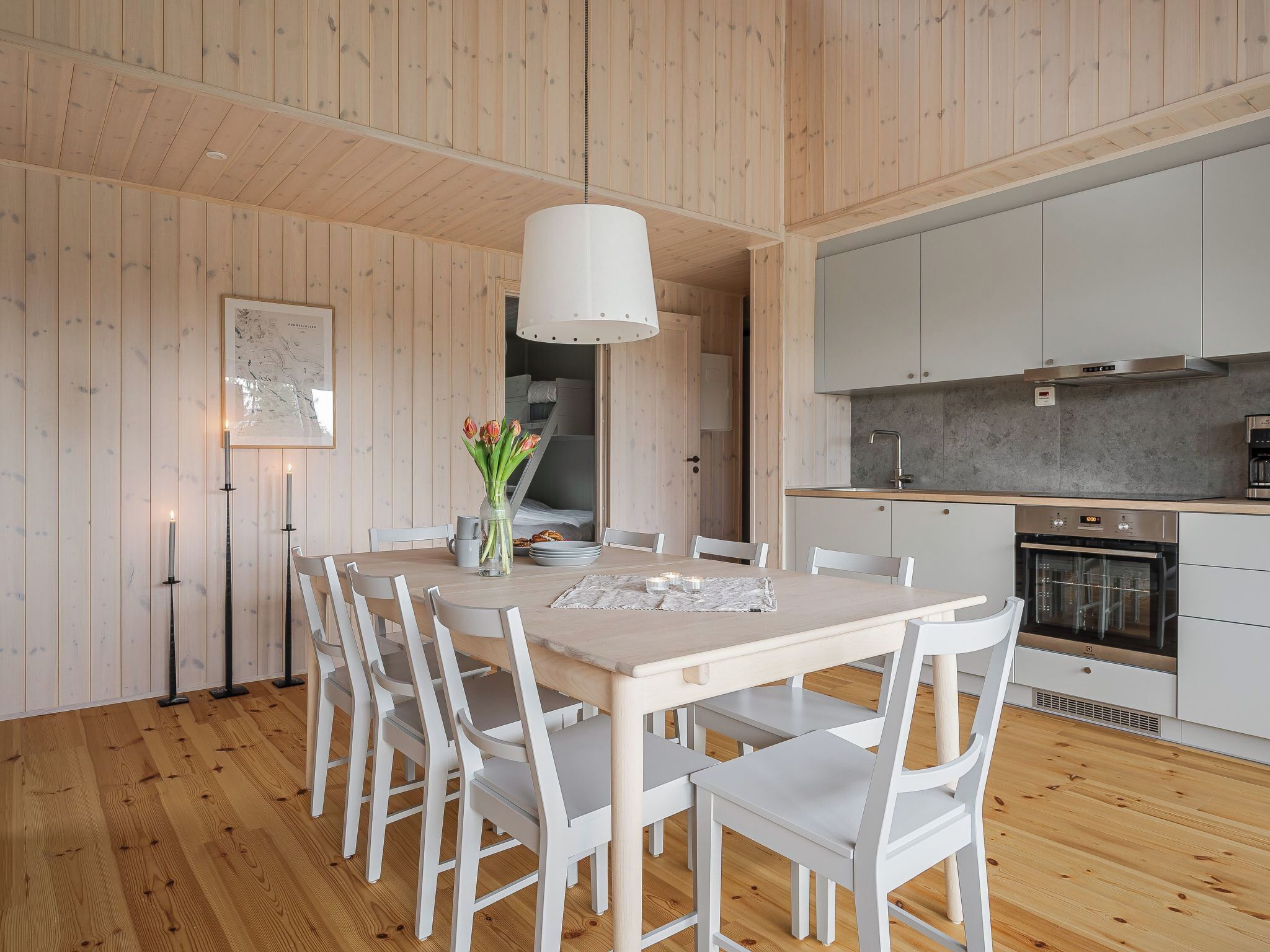 A modern kitchen with white cabinets, a built-in oven, and a grey countertop.