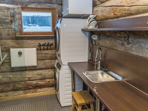 A compact kitchen with a sink, a refrigerator, and a window with a view of a snowy landscape. - Kaislaranta by Interhome (Salo)