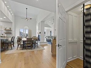 A spacious kitchen with a dining area, wooden flooring, and a modern ceiling fan.