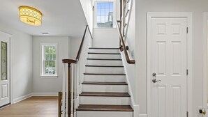 A staircase with wooden steps and white railings leading to a white door. - 7 Bedroom, 4 Full Baths, and Two Blocks to Beach (Cape May)