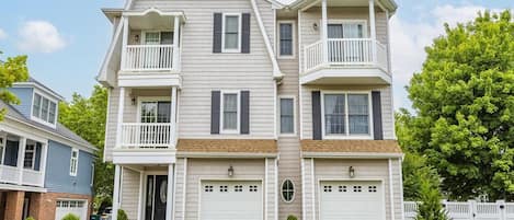 A two-story residential building with a central entrance, two balconies, and a garage.