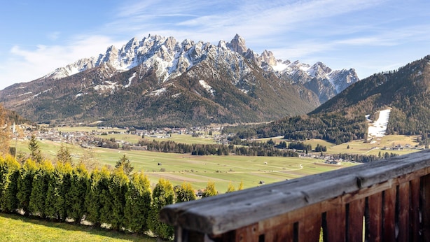 A mountainous landscape with a village in the valley. - Apartment 'Wegscheiderhof' with Mountain View, Private Terrace and Wi-Fi (Dobbiaco)