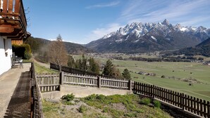 A mountain view with a wooden fence, a building with a balcony, and a clear sky. - Apartment 'Wegscheiderhof' with Mountain View, Private Terrace and Wi-Fi (Dobbiaco)