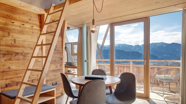 A wooden interior with a dining area, a ladder, and a view of mountains. - Studio 'Pavilion Earth' with Mountain View, Shared Terrace and Wi-Fi (Velturno)