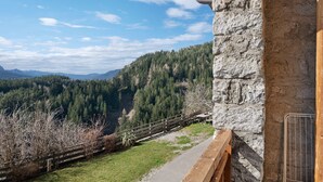 A stone building with a view of a forested valley and mountains. - Studio 'Pavilion Earth' with Mountain View, Shared Terrace and Wi-Fi (Velturno)