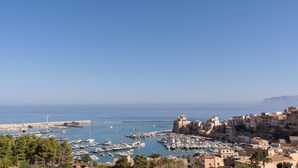Une ville côtière dotée d’un port de plaisance, de bâtiments historiques et d’un ciel d’un bleu éclatant.