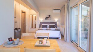 A bedroom with a bed, bedside tables, a window with curtains, and a view of a stone wall.