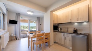 A modern kitchen with wooden cabinets, a stainless steel refrigerator, and a dining area with a table and chairs.