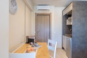 Une cuisine compacte équipée d’une machine à café, d’un évier et d’un lave-vaisselle.