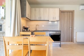 Una cocina moderna con armarios de madera, una mesa de comedor con sillas y un horno empotrado.