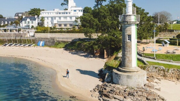 A coastal scene with a lighthouse, beach, and a large white building in the background. - Studio Apartment 'Vue Mer - 50m De La Plage' with Sea View, Private Terrace and Wi-Fi (Bénodet)