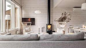 Una sala de estar acogedora con chimenea, asientos cómodos y televisor.