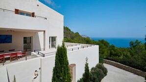 Un bâtiment moderne doté d’un balcon, d’un coin repas et offrant une vue sur la mer.