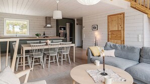 A modern kitchen with a central island, wooden ceiling, and a staircase. - Renen 6B by Interhome (Tännäskröket)