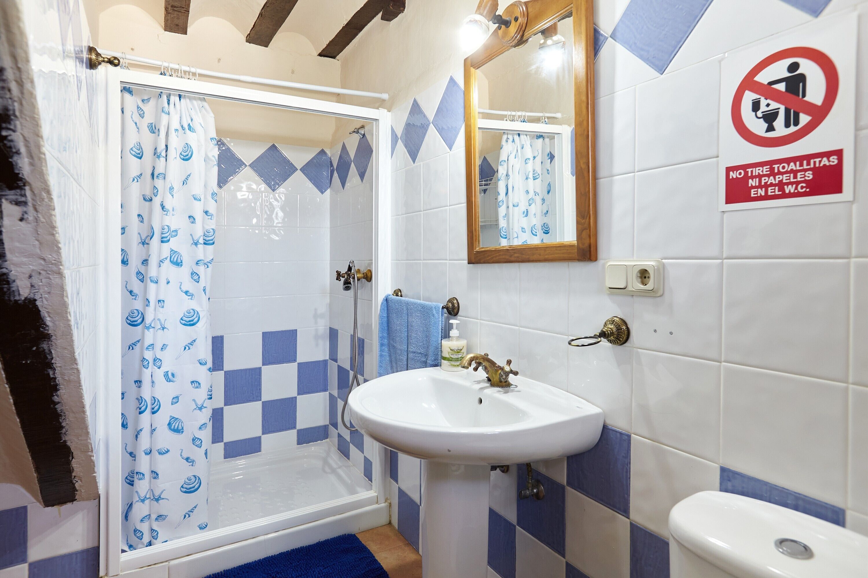 Een badkamer met douche, wastafel en toilet.