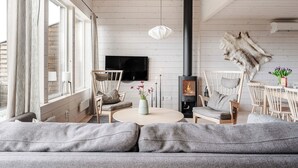 Een moderne woonkamer met een grote bank, een open haard en een wollen vloerkleed.