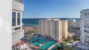 A high-rise hotel with a view of the beach and ocean.