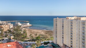 A coastal cityscape with a beach, high-rise buildings, and a clear sky.