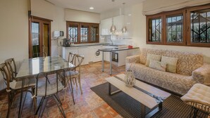 Una cocina moderna con comedor, un sofá y un ventilador de techo.
