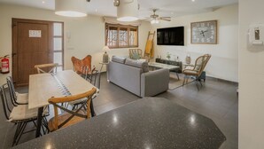 Un intérieur moderne comprenant un coin repas, un canapé et un ventilateur de plafond.