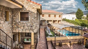 A stone building with a pool and outdoor seating.