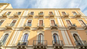 Un immeuble à plusieurs étages doté de balcons, de grandes fenêtres et de détails architecturaux classiques.