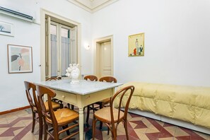 A dining area with a table, chairs, and a sofa.
