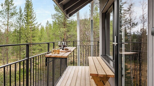 A wooden deck with a table and benches, overlooking a forested area. - Renstråket 2005 by Interhome (Tännäskröket)