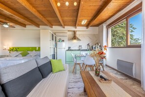 Une pièce chaleureuse avec un canapé, une table à manger et un coin cuisine.