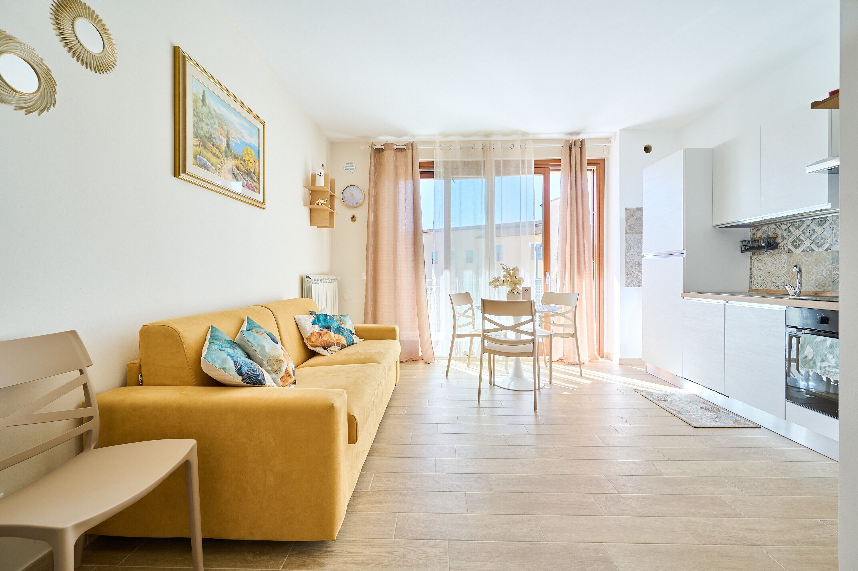 Una sala de estar con sofá, una mesa de comedor y una zona de cocina con estufa.