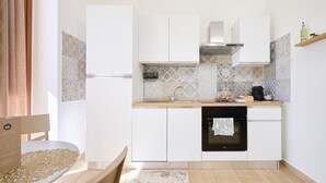 Et moderne køkken med hvide skabe, indbygget ovn og et mønstret backsplash.