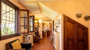 Un pasillo con un sofá, armarios de madera y una puerta que da a otra habitación.