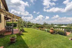 A well-maintained garden with a patio area, outdoor furniture, and a swimming pool.
