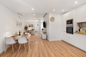 A modern kitchen with white cabinetry, a built-in oven, and a microwave.