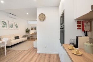 Una sala moderna con un sofá, una mesita de centro y un reloj montado en la pared.